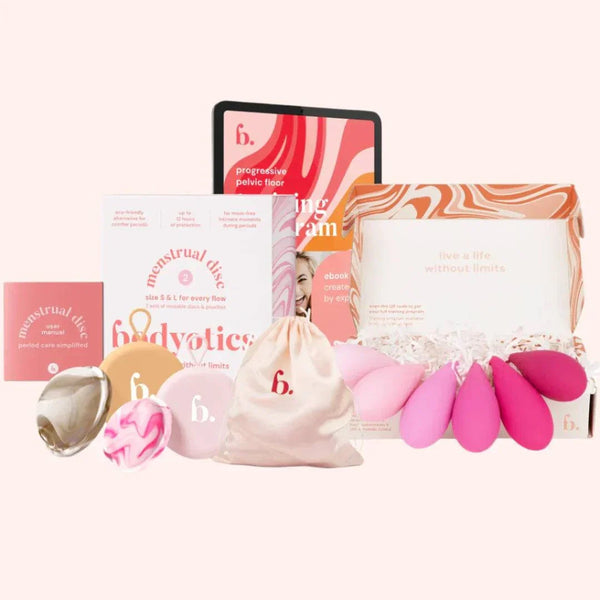 Bodyotics Kegel weights set with six graduated sizes, reusable menstrual discs in beige and pink, carrying pouch, and instructional guides for pelvic floor care.
