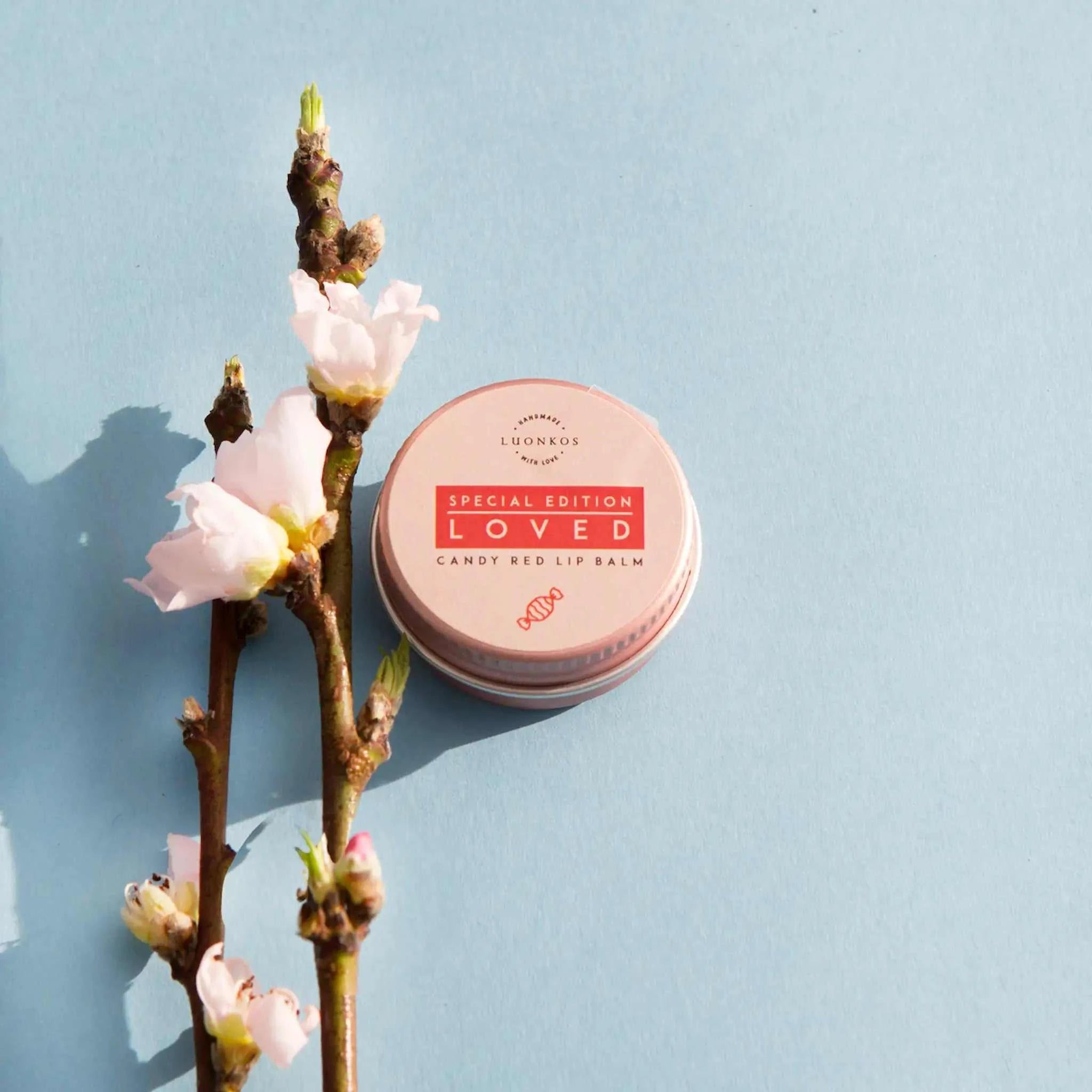 Loved candy red lip balm lifestyle model photo – woman with vibrant red lips and natural lip care