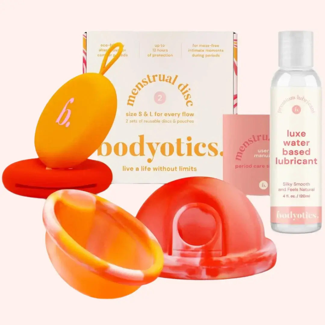 Bodyotics water-based lube bottle with orange reusable menstrual discs and a carry pouch set