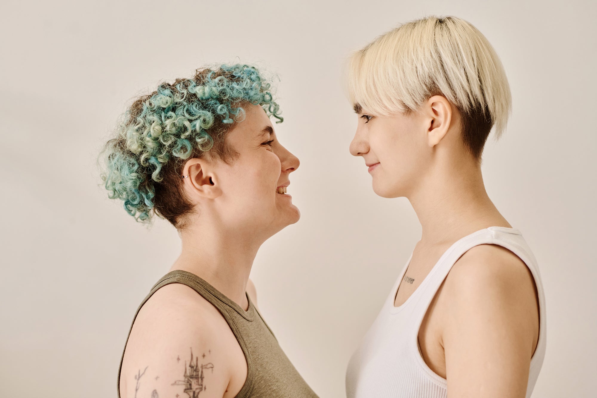 portrait-happy-lesbian-couple-looking-each-other-against-white-background.jpg